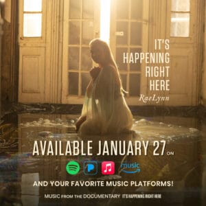 An advertisement for RaeLynn's song, "It's Happening Right Here" featuring a photograph of RaeLynn kneeling in a white gown.